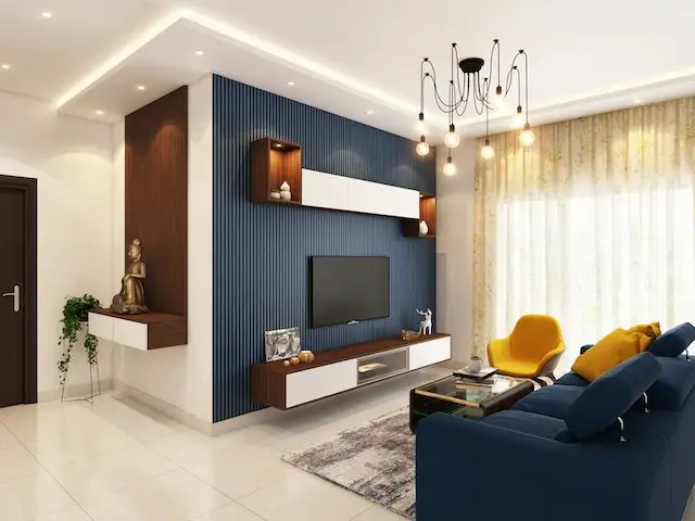 Contemporary living room with blue accent wall, mounted TV, floating shelves, and dark blue sofa