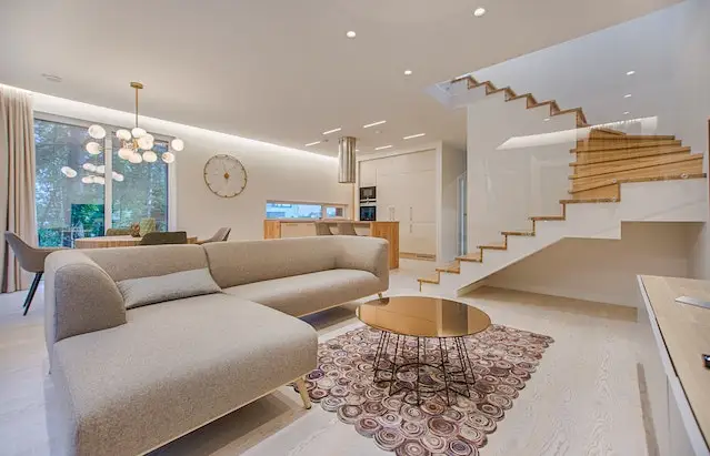 Open concept living and dining area with curved beige sofa